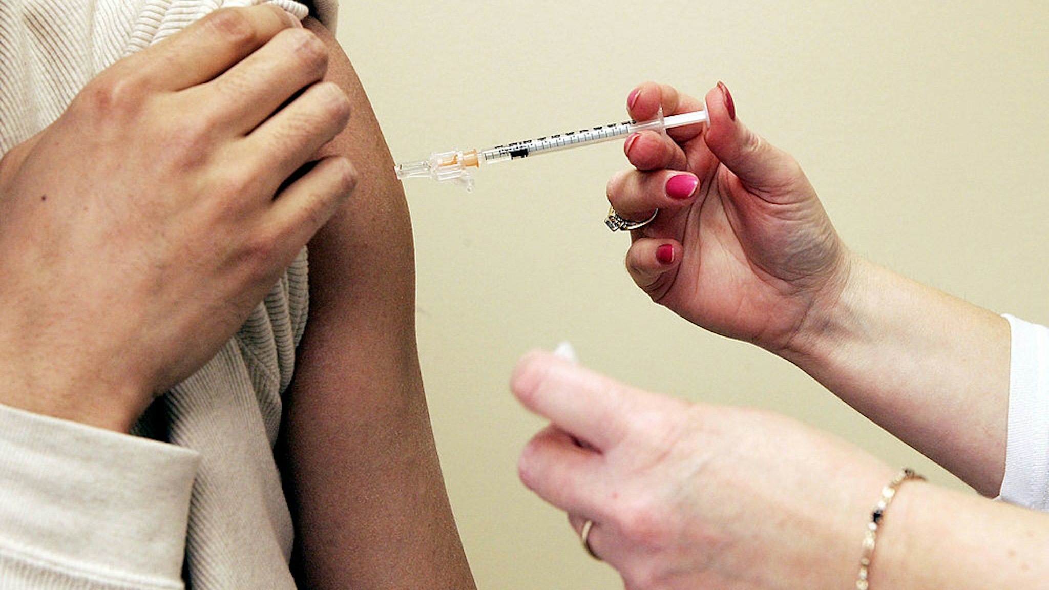 Nurse Coordinator Lisa Chrisley (R) injects an experimental flu vaccine into the arm of volunteer Kwisa Kang of Mt. Washington, Maryland, a medical school researcher, during a clinical trial to test the effectiveness of the vaccine to combat avian influenza April 5, 2005 at University of Maryland School of Medicine in Baltimore, Maryland.