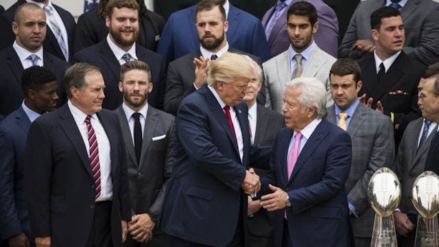 U.S. President Donald Trump (C) shakes hands with Robert Kraft (R), owner of the 2017 Super Bowl Champions the New England Patriots, at the White House in Washington, United States on April 19, 2017.