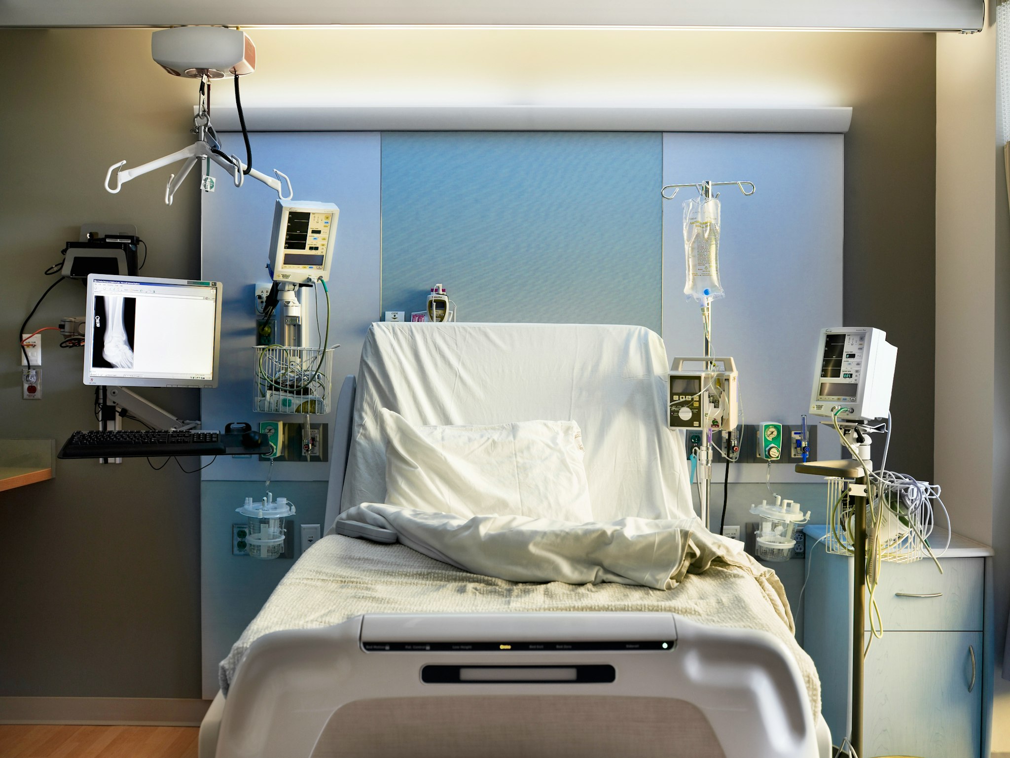 Straight-on view of empty hospital bed with medical equipment.