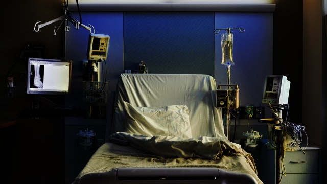 Straight-on view of empty hospital bed with medical equipment.