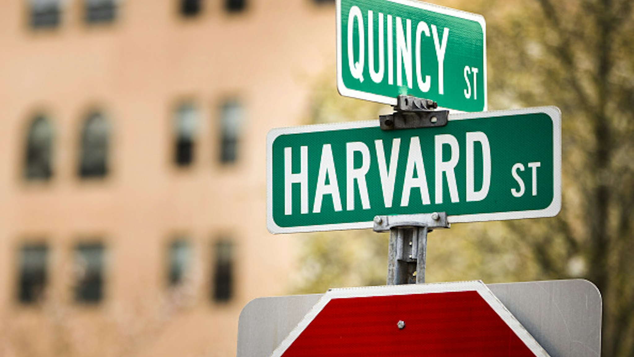 A street sign stands at the intersection of Quincy and Harvard streets near Harvard University in Cambridge, Massachusetts, U.S., on Monday, April 20, 2020. College financial aid offices are bracing for a spike in appeals from students finding that the aid packages they were offered for next year are no longer enough after the coronavirus pandemic cost their parents jobs or income.