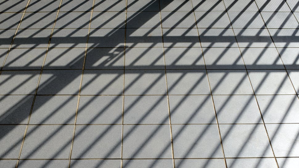 Shadow of a wrought iron gate on a floor