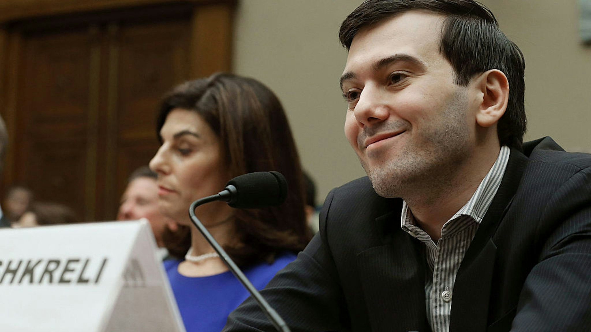 WASHINGTON, DC - FEBRUARY 04: Martin Shkreli, former CEO of Turing Pharmaceuticals LLC., smiles while flanked by Nancy Retzlaff, chief commercial officer for Turing Pharmaceuticals LLC., during a House Oversight and Government Reform Committee hearing on Capitol Hill, February 4, 2016 in Washington, DC. Mr. Shkreli invoked his 5th Amendment right not to testify to the committee that is examining the prescription drug market.