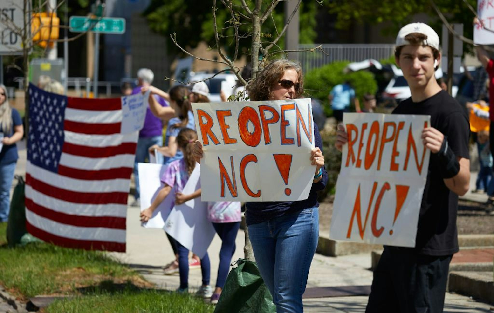 Protesters from a grassroots organization called REOPEN NC demonstrate against the North Carolina coronavirus lockdown at a parking lot adjacent to the North Carolina State Legislature in Raleigh, North Carolina, on April 14, 2020. - The group was demanding the state economy be opened up no later than April 29. (Photo by Logan Cyrus / AFP)