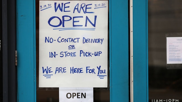 BOSTON, MA - MARCH 20: A sign on the door of Fenway restaurant Saloniki Greek alerts customers that the store is only open for takeout and deliveries in Boston on March 20, 2020.The company had to let most of its employees go, most of them immigrants, as restaurants shut down to prevent the spread of coronavirus. Saloniki Greek will take a takeout/catering tack for at least a week, to see if they can weather this crisis, with managers, including Ben, doing the cooking and deliveries. They are also donating food to hospitals.