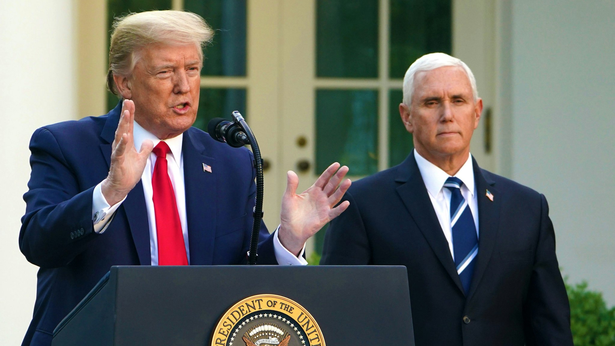 US President Donald Trump speaks as US Vice President Mike Pence look on during a news conference on the novel coronavirus, COVID-19, in the Rose Garden of the White House in Washington, DC on April 27, 2020.