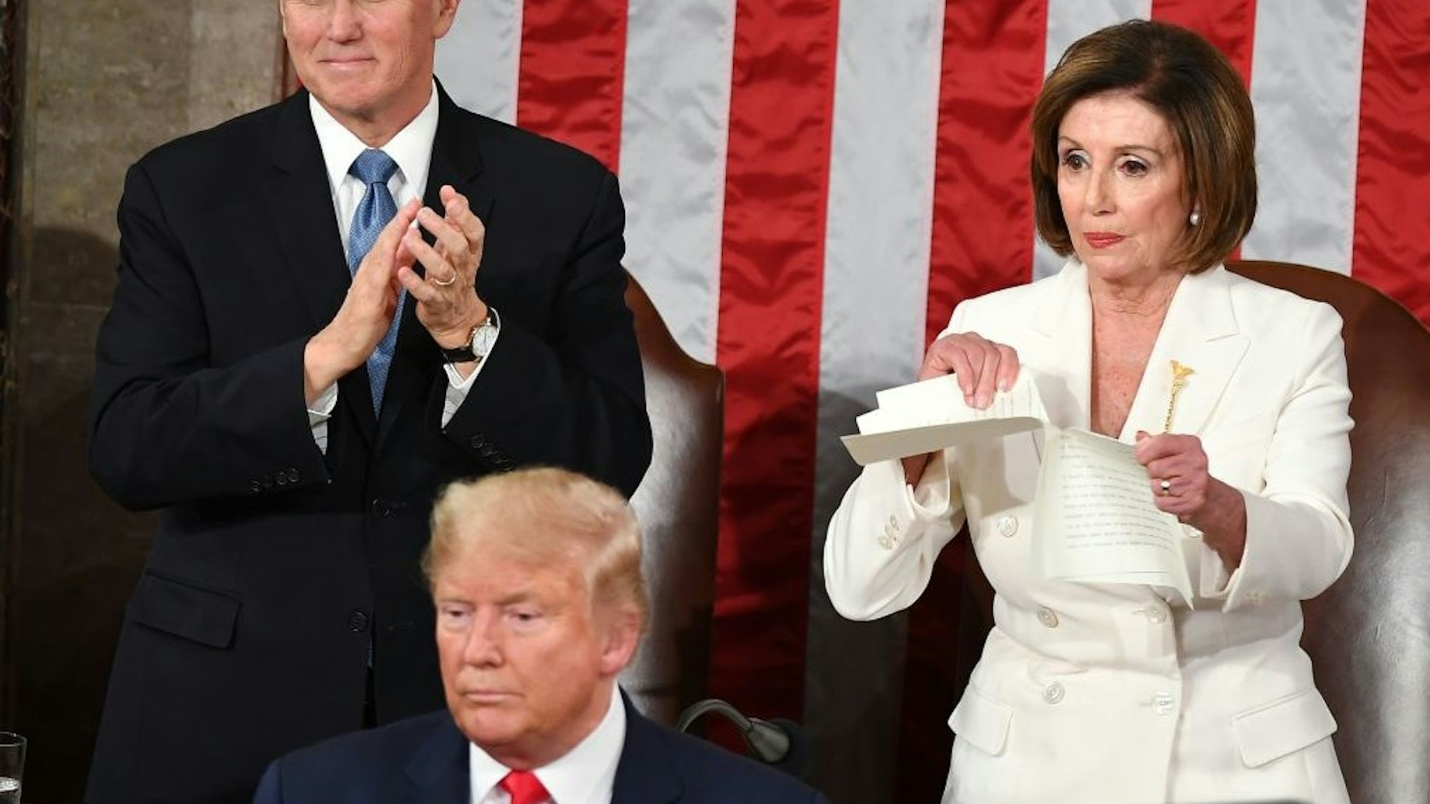 TOPSHOT - Speaker of the US House of Representatives Nancy Pelosi rips a copy of US President Donald Trumps speech after he delivered the State of the Union address at the US Capitol in Washington, DC, on February 4, 2020. (Photo by MANDEL NGAN / AFP) (Photo by