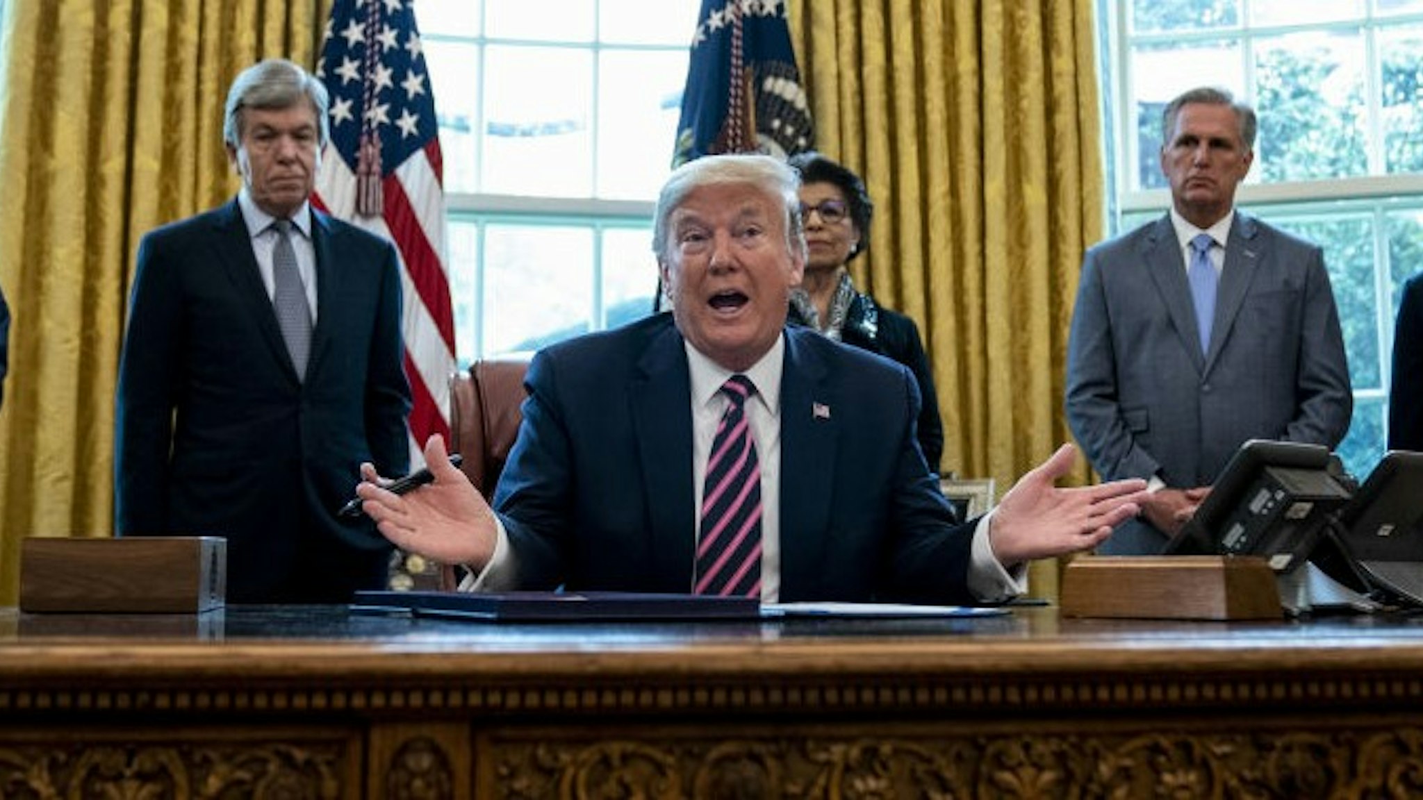U.S. President Donald Trump speaks during a signing ceremony for H.R. 266, The Paycheck Protection Program and Health Care Enhancement Act, with members of his administration and Republican lawmakers in the Oval Office of the White House in Washington, D.C., U.S., on Friday, April 24, 2020. Trump signed the $484 billion spending package that includes more money for small businesses, the latest bid by Washington lawmakers to rescue an economy devastated by the coronavirus pandemic. Photographer: