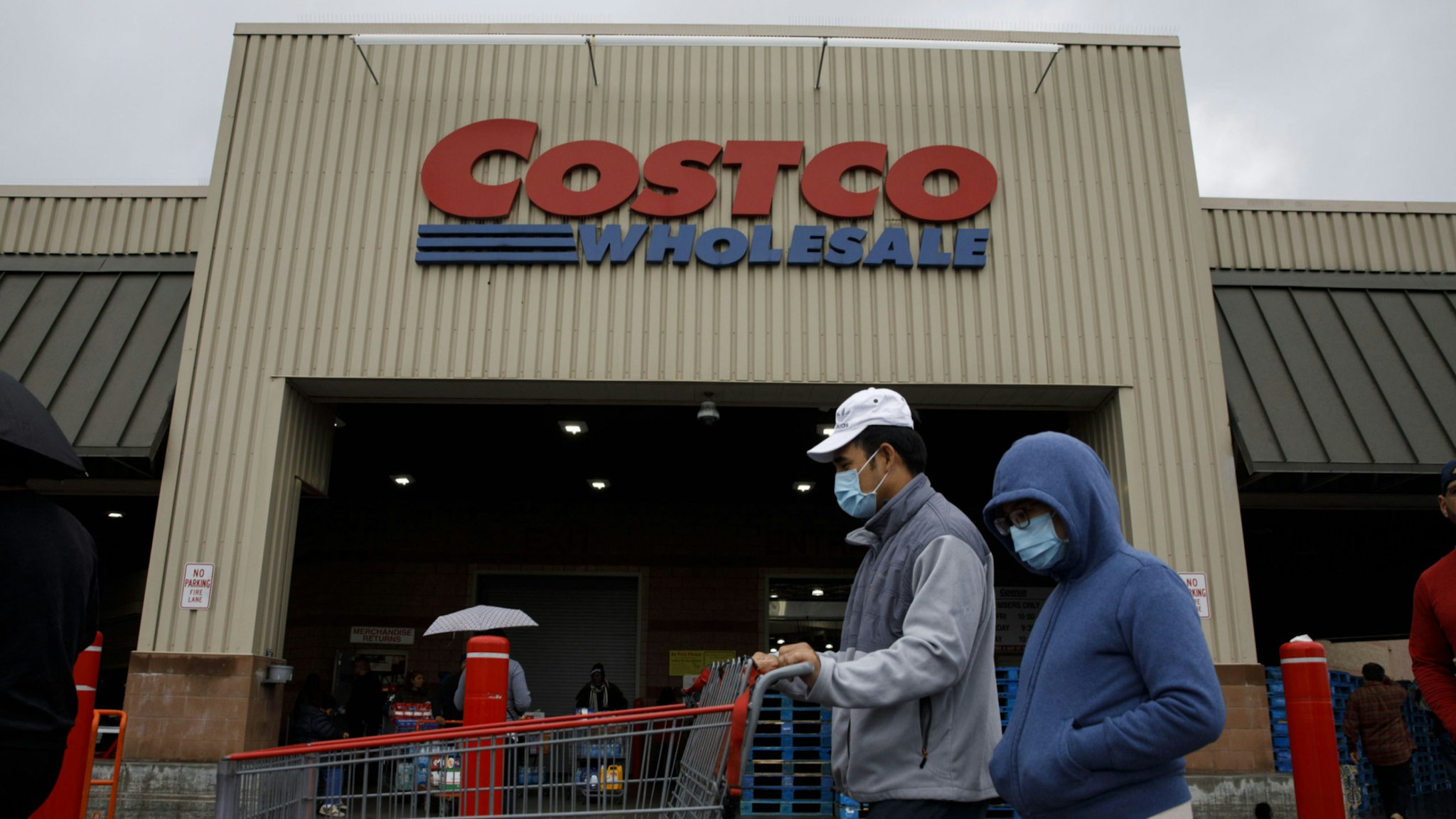Shoppers wear protective masks while waiting in line to enter a Costco Wholesale Corp. location in Hawthorne, California, U.S., on Saturday, March 14, 2020.