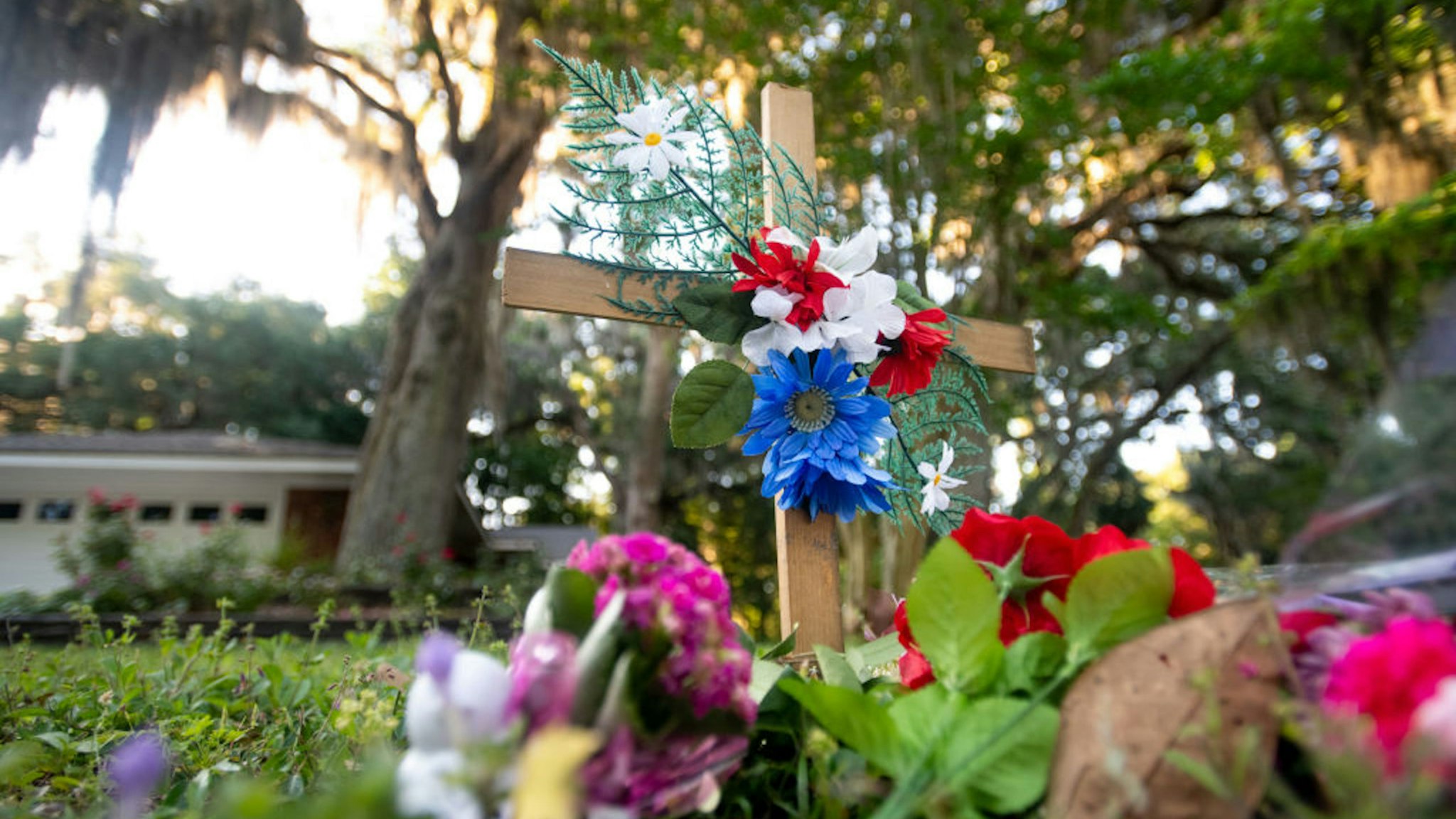 BRUNSWICK, GA - MAY 07: A cross with flowers sits near the intersection of Satilla Rd. and Holmes Rd. in the Satilla Shores neighborhood where Ahmaud Arbery was shot and killed May 7, 2020 in Brunswick, Georgia. Arbery was shot during a confrontation with an armed father and son on Feb. 23.