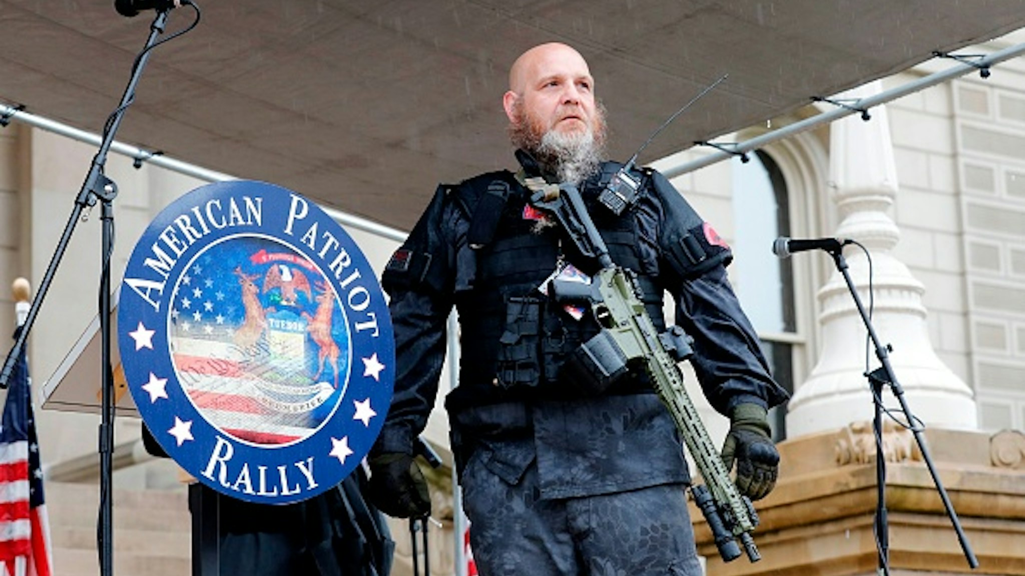 Armed protesters provide security as demonstrators take part in an "American Patriot Rally," organized on April 30, 2020, by Michigan United for Liberty on the steps of the Michigan State Capitol in Lansing, demanding the reopening of businesses. - Michigan's stay-at-home order declared by Democratic Governor Gretchen Whitmer is set to expire after May 15.