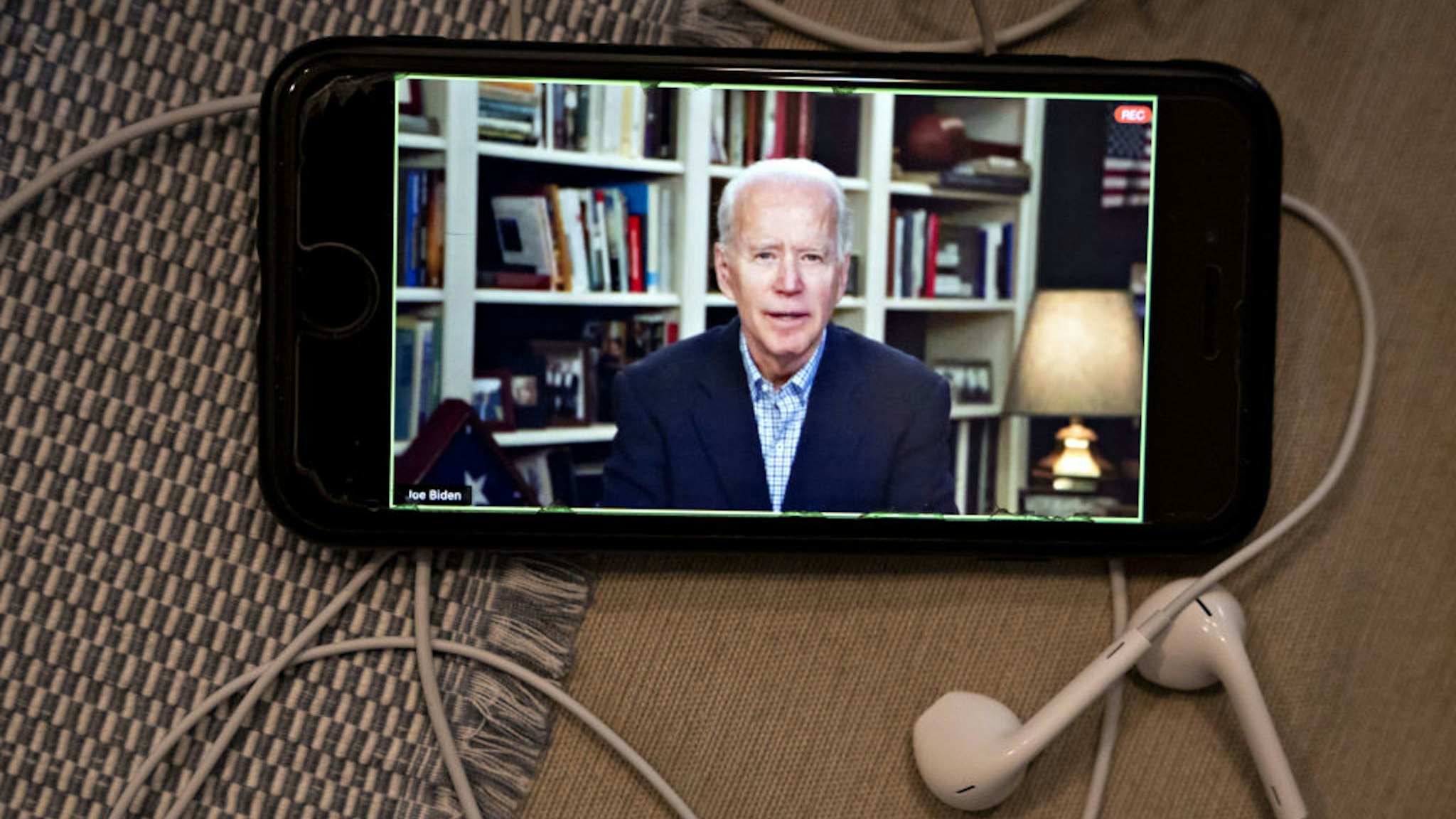 Former Vice President Joe Biden, 2020 Democratic presidential candidate, speaks during a virtual press briefing on a smartphone in this arranged photograph in Arlington, Virginia, U.S., on Wednesday, March 25, 2020. During the livestreamed news conference today, Biden said he didn't see the need for another debate, which the Democratic National Committee had previously said would happen sometime in April.