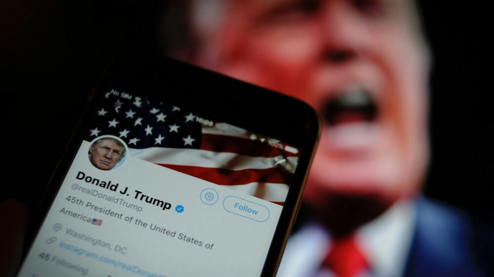 The Twitter app is seen with an image of US president Donald Trump in the background in this photo illustration on December 4, 2017.