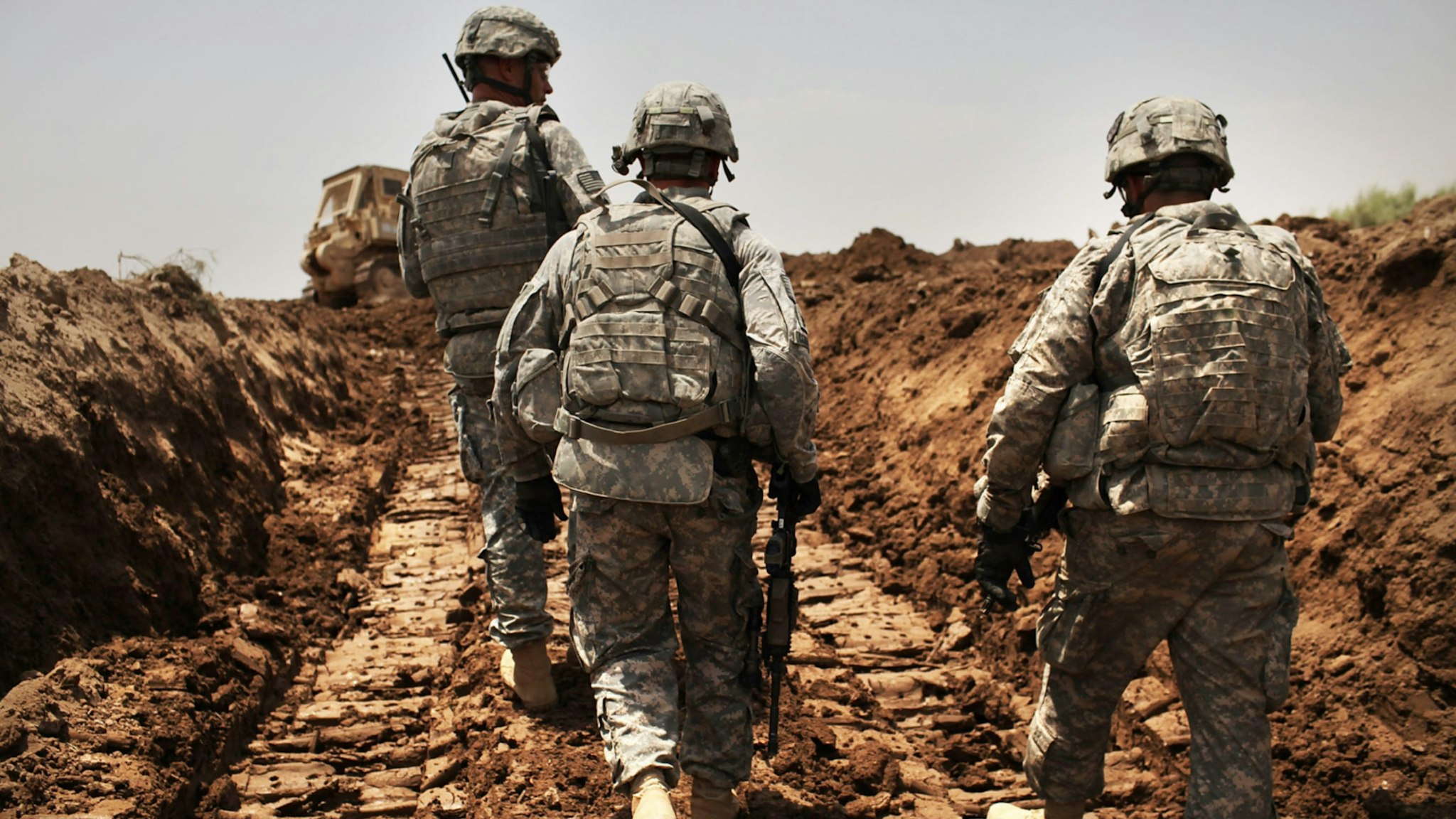 U.S. soldiers with the 3rd Armored Cavalry Regiment patrol a new ditch they have dug to protect the base from attack on July 19, 2011 in Iskandariya, Babil Province Iraq.