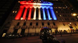 Coronavirus Frontliners Support A view of the fearless girl with the New York Stock Exchange on the background lit in different colors as support for Frontliners during Coronavirus pandemic on May 5, 2020. (Photo by John Nacion/NurPhoto)
