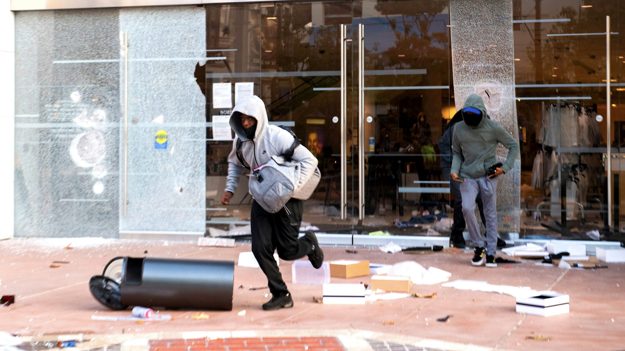 People are seen looting stores at the Grove shopping center in the Fairfax District of Los Angeles on May 30, 2020 following a protest against the death of George Floyd, an unarmed black man who died while while being arrested and pinned to the ground by the knee of a Minneapolis police officer. - Clashes broke out and major cities imposed curfews as America began another night of unrest Saturday with angry demonstrators ignoring warnings from President Donald Trump that his government would stop violent protests over police brutality "cold."