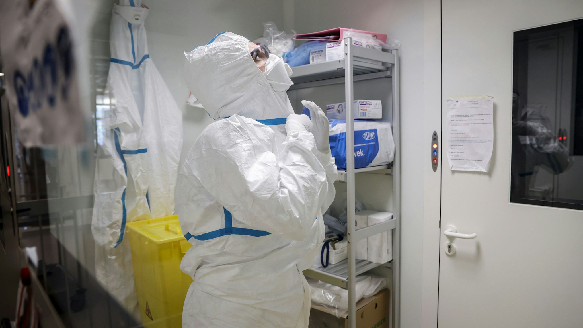 A laboratory operator puts on a protective gear before handling patients' samples in a laboratory of the National Reference Center (CNR) for respiratory viruses at the Institut Pasteur in Paris on January 28, 2020. - The CNR analyses the tests for respiratory viruses among which coronavirus. The deadly new coronavirus that has broken out in China, 2019-nCoV, has so far killed 106 people and infected over 4,000 -- the bulk of them in and around Wuhan.