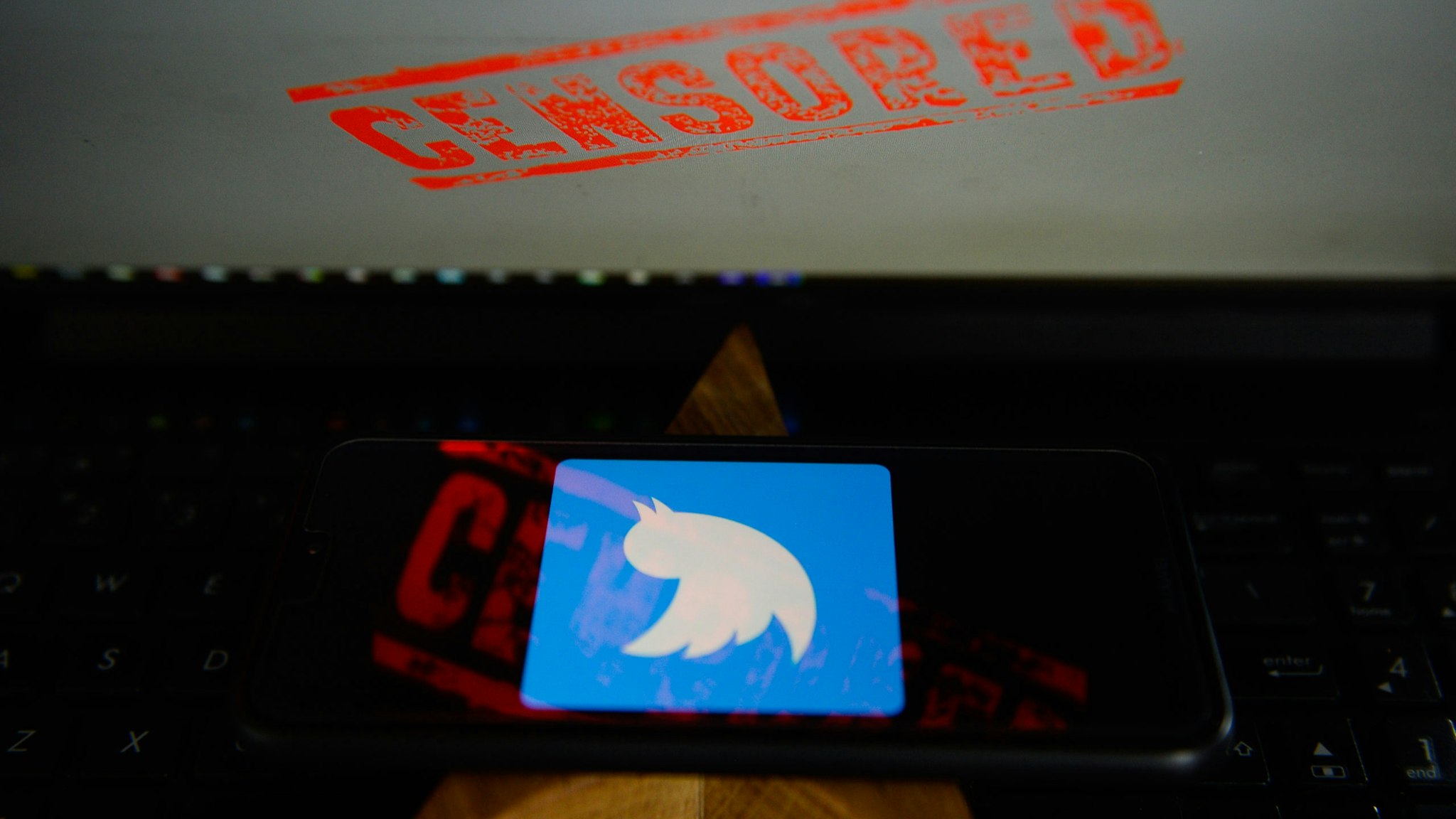 KRAKOW, POLAND - 2018/08/17: In this photo illustration, the Twitter logo is seen on a Huawei smartphone with the word censored on a laptop monitor. (Photo Illustration by Omar Marques/SOPA Images/SOPA Images/LightRocket via Getty Images)