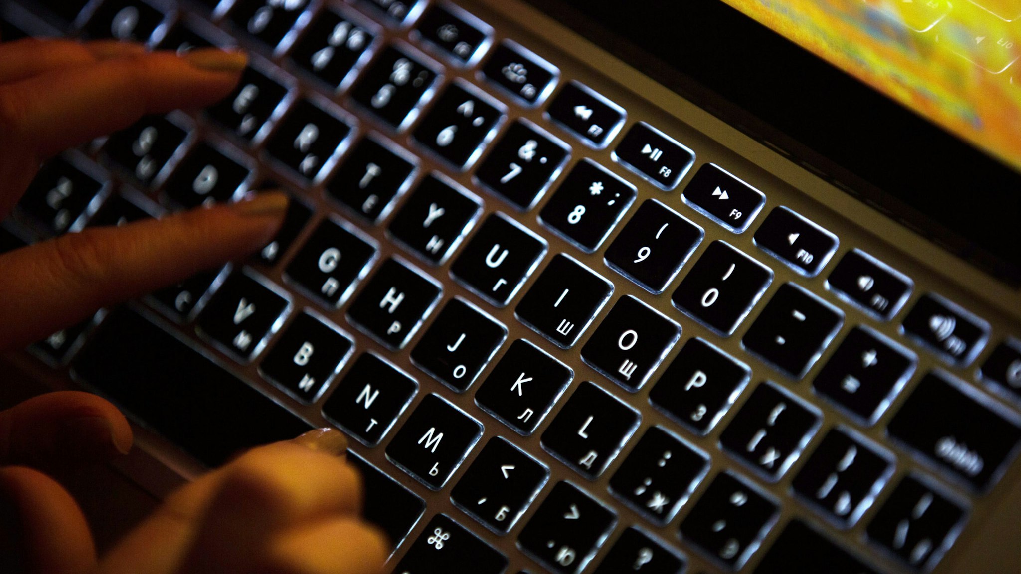 A person uses a laptop computer with illuminated English and Russian Cyrillic character keys in this arranged photograph in Moscow, Russia, on Thursday, March 14, 2019. Russian internet trolls appear to be shifting strategy in their efforts to disrupt the 2020 U.S. elections, promoting politically divisive messages through phony social media accounts instead of creating propaganda themselves, cybersecurity experts say. Photographer: Andrey Rudakov/Bloomberg via Getty Images