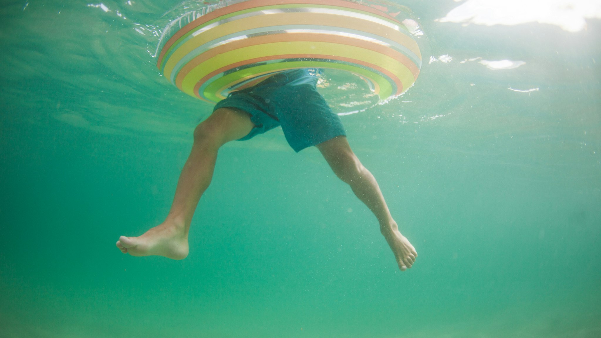 Underwater view of a boy in an inflatable rubber ring, California, United States - stock photo
