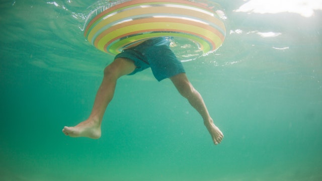 Underwater view of a boy in an inflatable rubber ring, California, United States - stock photo
