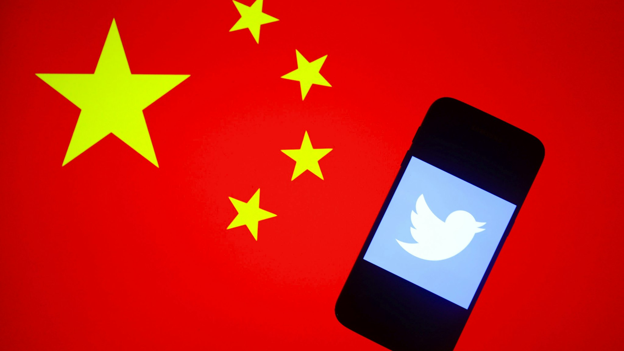 witter logo is displayed on a mobile phone screen photographed on the People's Republic of China national flag background arranged for illustration photo taken in Krakow, Poland on 15th January, 2020. (Photo illustration by Beata Zawrzel/NurPhoto via Getty Images)