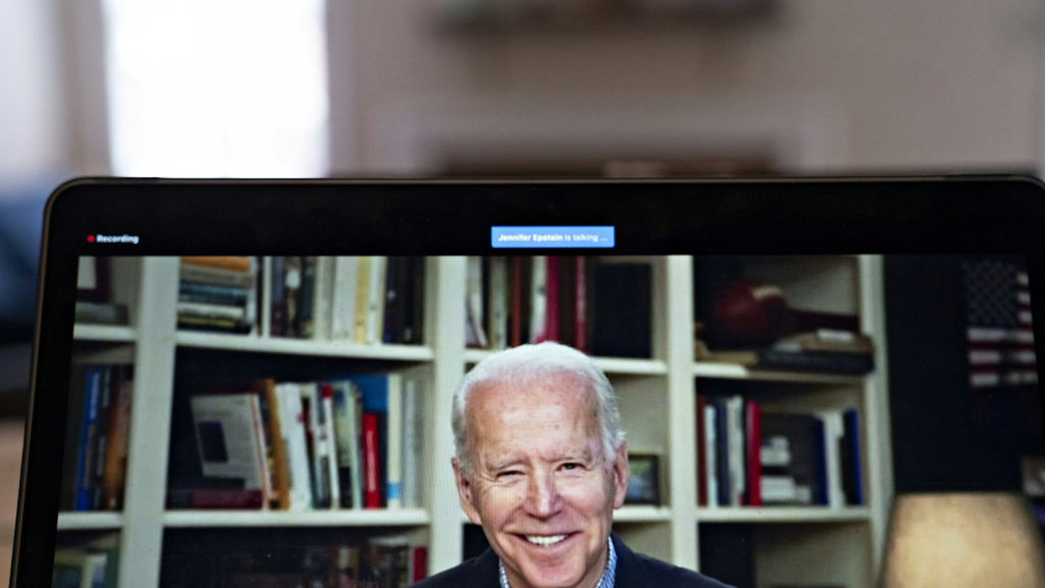 Former Vice President Joe Biden, 2020 Democratic presidential candidate, smiles during a virtual press briefing on a laptop computer in this arranged photograph in Arlington, Virginia, U.S., on Wednesday, March 25, 2020.