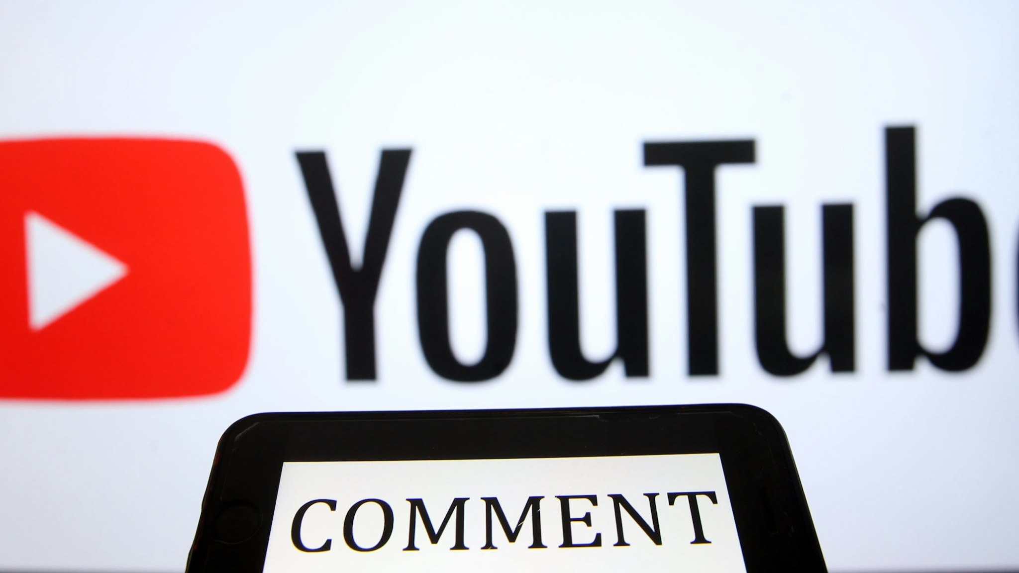ANKARA, TURKEY - APRIL 28: YouTube logo is being displayed behind a text reading "comment" on a smart phone screen in Ankara, Turkey on April 28, 2020. Evrim AydÄ±n / Anadolu Agency
