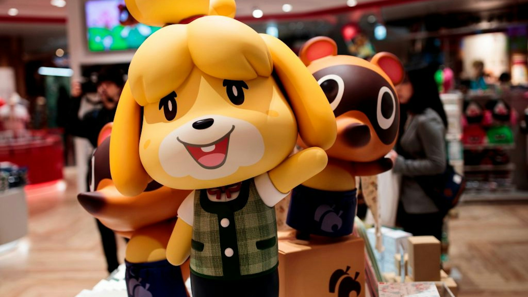 This picture taken on November 19, 2019 shows dolls of Nintendo game characters Isabelle (C), known as Shizue in Japan, and Tom Nook (R), known in Japan as Tanukichi, from the Animal Crossing series of video games as they are displayed at a new Nintendo store during a press preview in Tokyo.