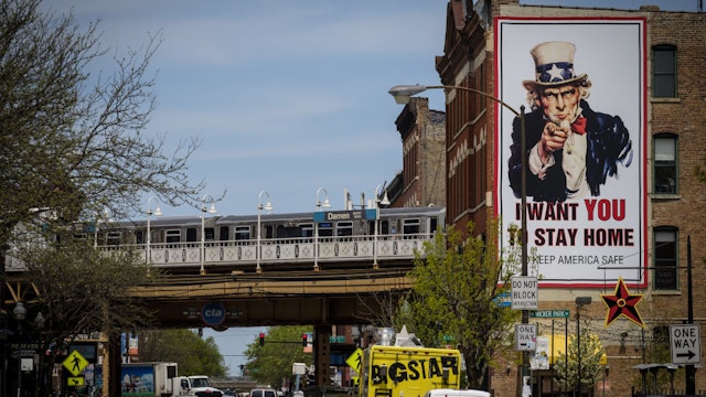 A L train passes an "I Want You To Stay Home" billboard in Chicago, Illinois, U.S., on Thursday, May 7, 2020.