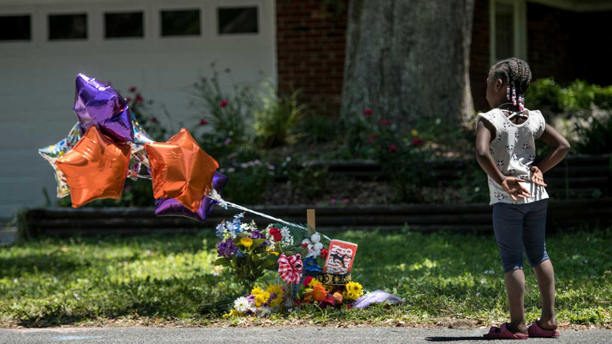 A young girl looks at a memorial for Ahmaud Arbery near where he was shot and killed May 8, 2020 in Brunswick, Georgia