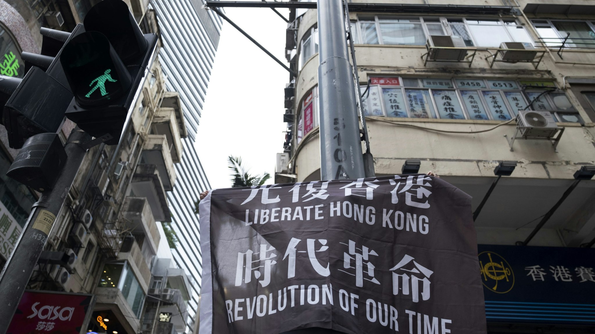 A demonstrator raises a flag reading "Liberate Hong Kong, Revolution of Our Time" during a protest in Hong Kong, China, on Wednesday, May 27, 2020. Officers fired pepper spray projectiles in downtown Hong Kong and arrested at least 16 people as protesters hit the streets Wednesday to oppose China's increasing control over the city, a return to unrest largely unseen since last year. Photographer: Justin Chin/Bloomberg via Getty Images