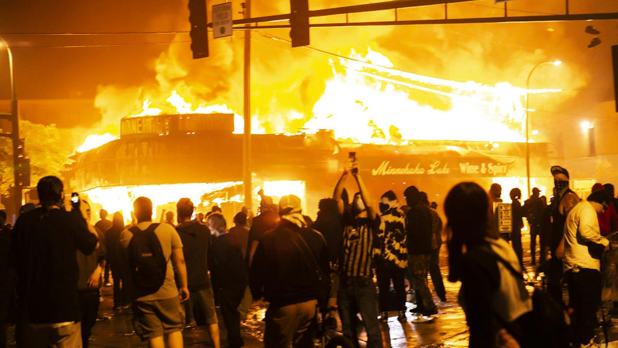 Protestors set a shop on fire on Thursday, May 28, 2020, during the third day of protests over the death of George Floyd in Minneapolis.
