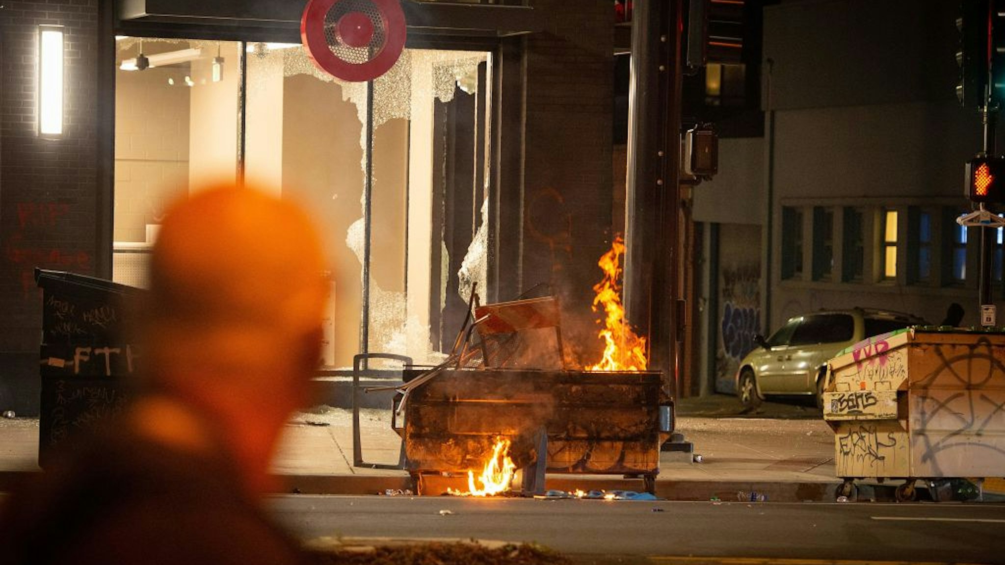 A dumpster is lit on fire infront of a Target store in Oakland California on May 30, 2020, over the death of George Floyd, a black man who died after a white policeman kneeled on his neck for several minutes.