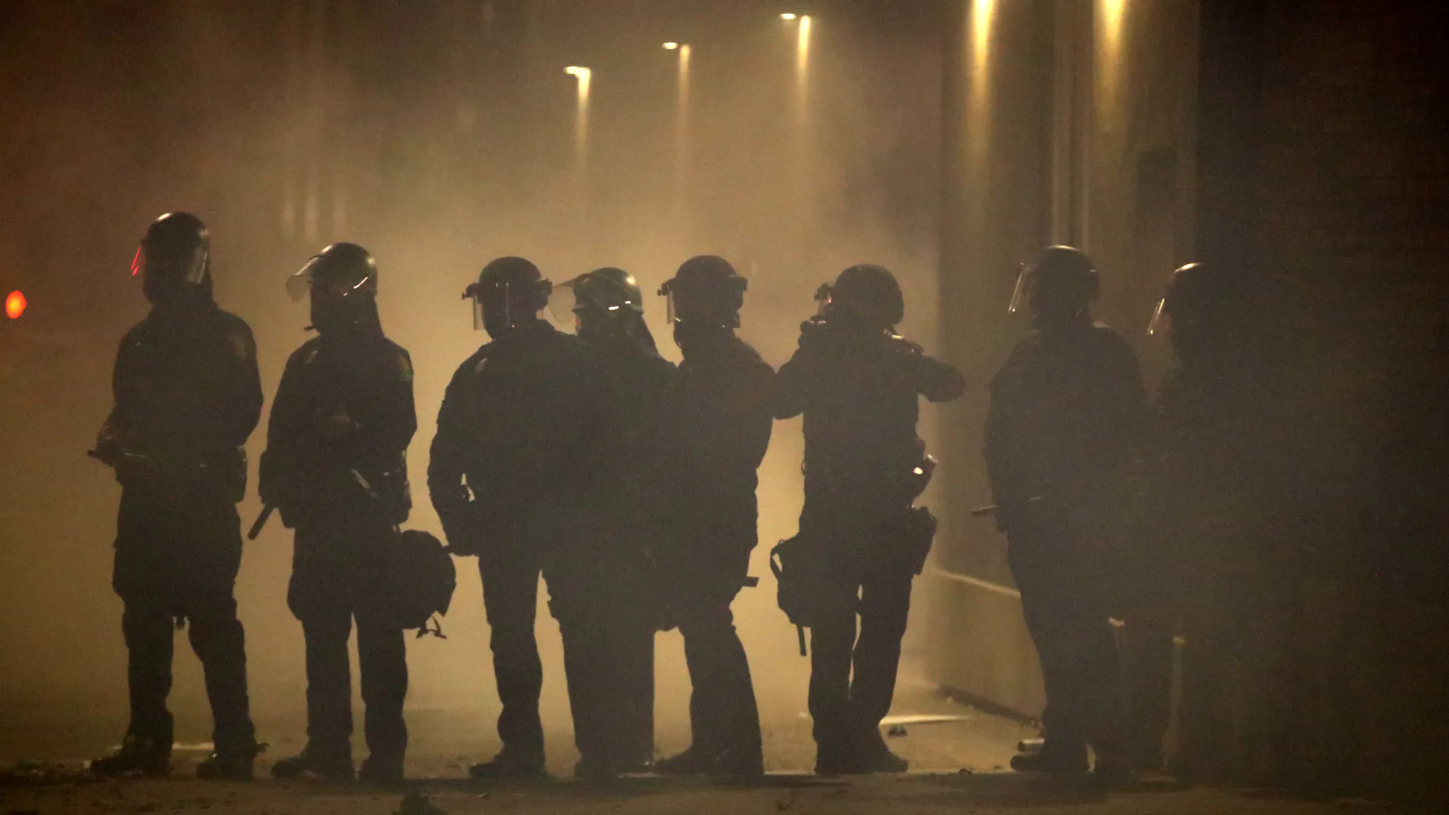 Activists In Oakland Protest Police Brutality In Death Of George Floyd OAKLAND, CALIFORNIA - MAY 29: Police officers stand in a fog of tear gas during a protest sparked by the death of George Floyd while in police custody on May 29, 2020 in Oakland, California. Earlier today, former Minneapolis police officer Derek Chauvin was taken into custody for Floyd's death. Chauvin has been accused of kneeling on Floyd's neck as he pleaded with him about not being able to breathe. Floyd was pronounced dead a short while later. Chauvin and 3 other officers, who were involved in the arrest, were fired from the police department after a video of the arrest was circulated. (Photo by Justin Sullivan/Getty Images)