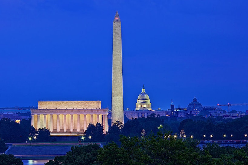A skyline view of Washington, District of Columbia at dusk. The Lincoln Memorial, Washington Monument and the U.S. Capitol Building illuminate the Washington, D.C. skyline as seen from the nearby Iwo Jima Memorial in Rosslyn, Virginia.