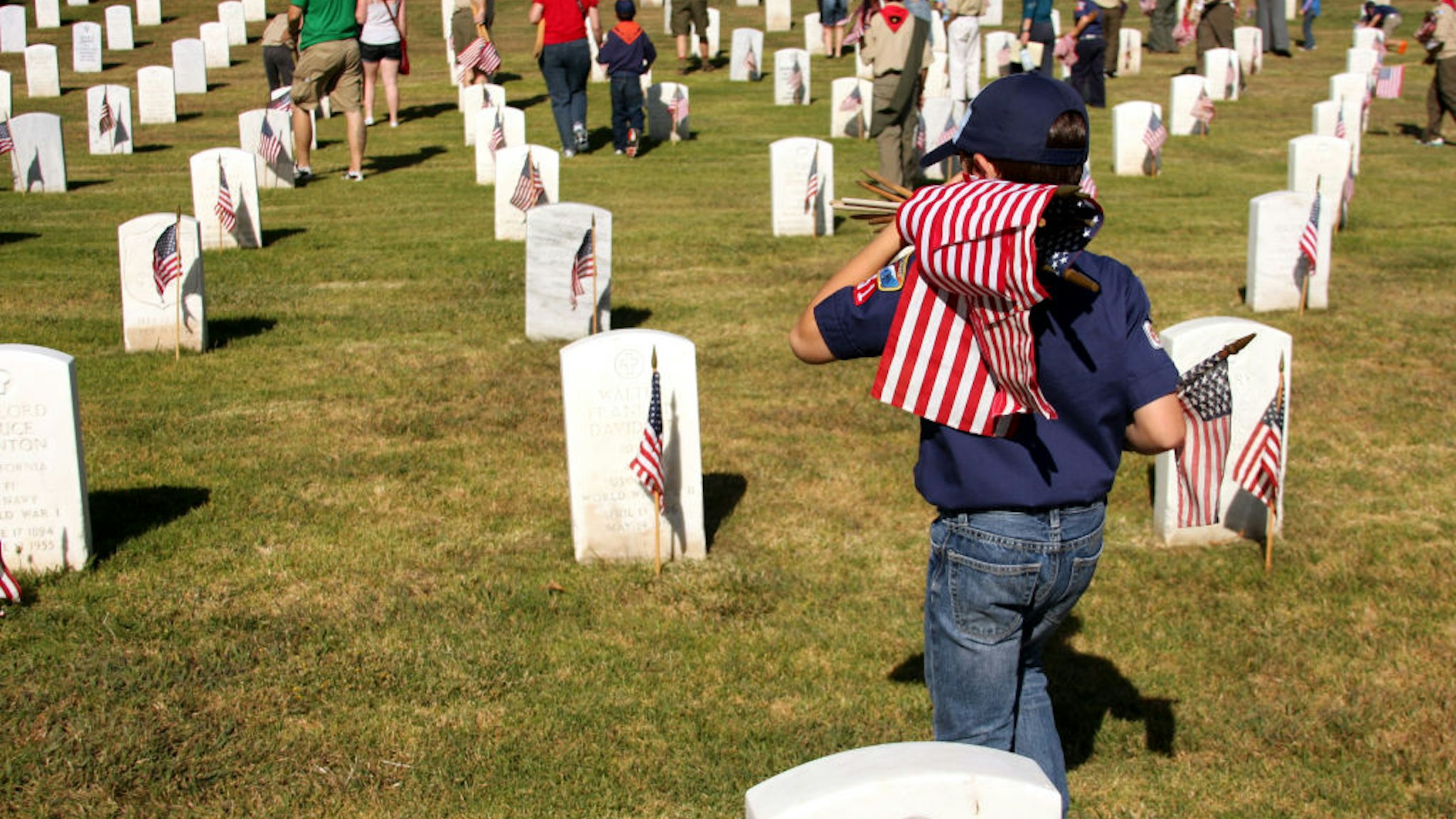 Cub Scout Carrying Flags to Place at Graves of Veterans on Memorial Day