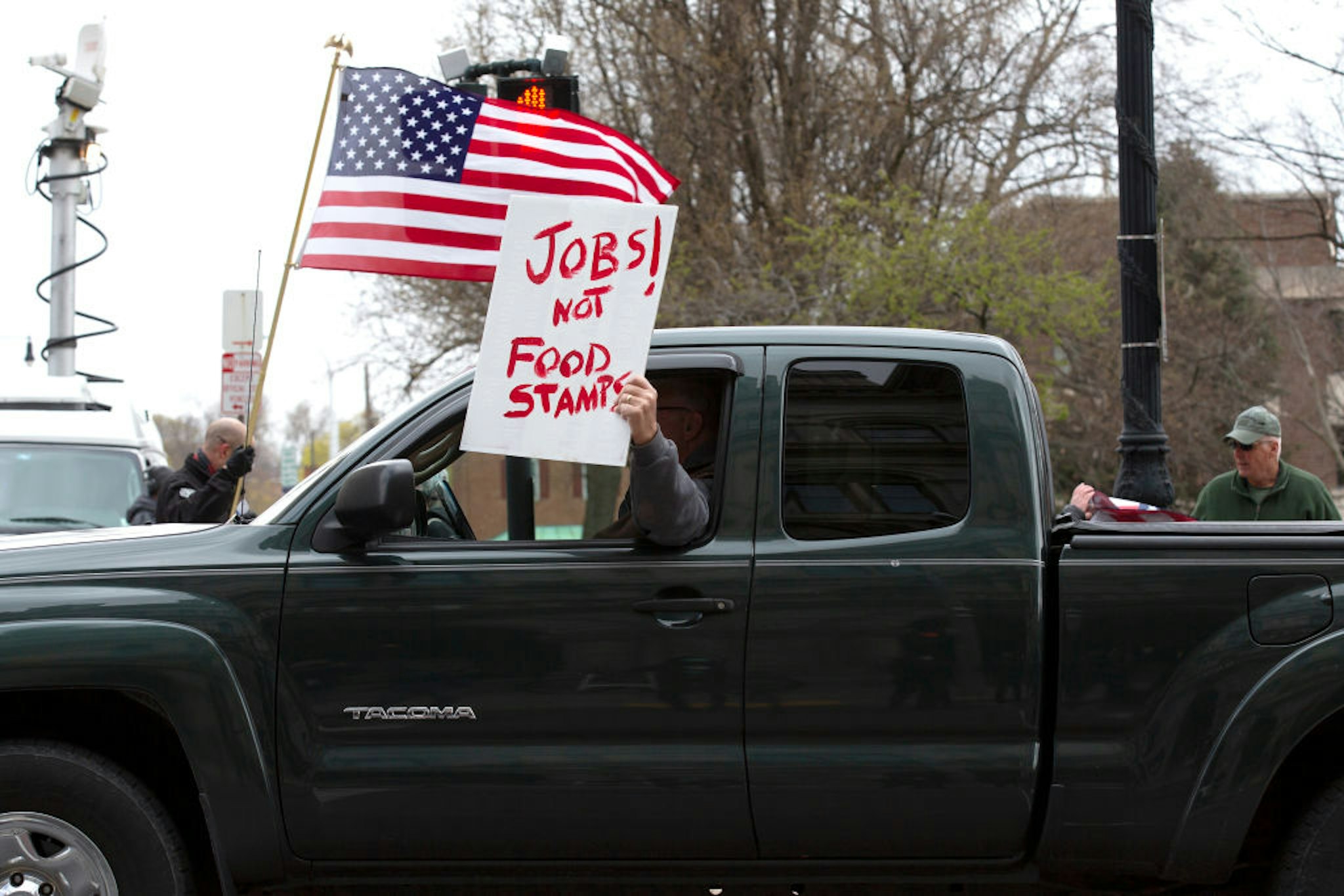 ALBANY, NY - APRIL 22: A protestor holds a sign out the window of their vehicle during an Operation Gridlock protest outside of the New York State Capitol Building on April 22, 2020 in Albany, New York. Protestors are calling on New York State Governor Andrew Cuomo to reopen New York State amidst a shutdown of all non-essential businesses due to the Coronavirus pandemic. (Photo by Stefani Reynolds/Getty Images)