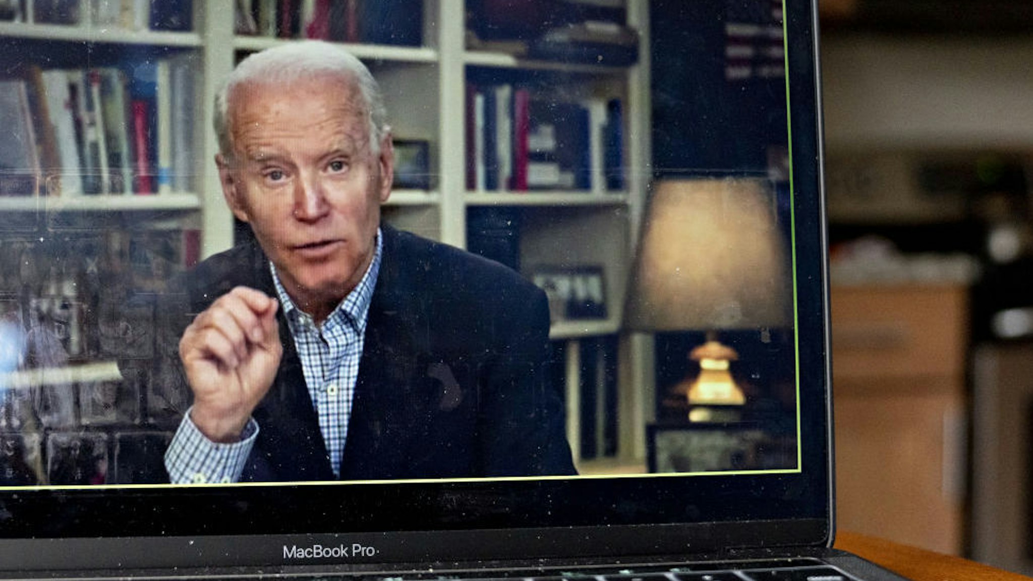 Former Vice President Joe Biden, 2020 Democratic presidential candidate, speaks during a virtual press briefing on a laptop computer in this arranged photograph in Arlington, Virginia, U.S., on Wednesday, March 25, 2020. During the livestreamed news conference today, Biden said he didn't see the need for another debate, which the Democratic National Committee had previously said would happen sometime in April. Photographer: Andrew Harrer/Bloomberg