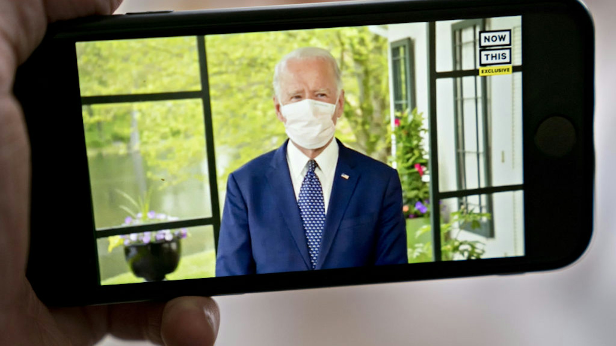 Former Vice President Joe Biden, presumptive Democratic presidential nominee, wears a protective mask during a NowThis economic address seen on a smartphone in Arlington, Virginia, U.S., on Friday, May 8, 2020. A super political action committee backing Joe Biden will launch a $10 million television ad campaign touting the presumptive Democratic nominee's leadership on the economic recovery after the 2008 financial crisis. Photographer: Andrew Harrer/Bloomberg via Getty Images