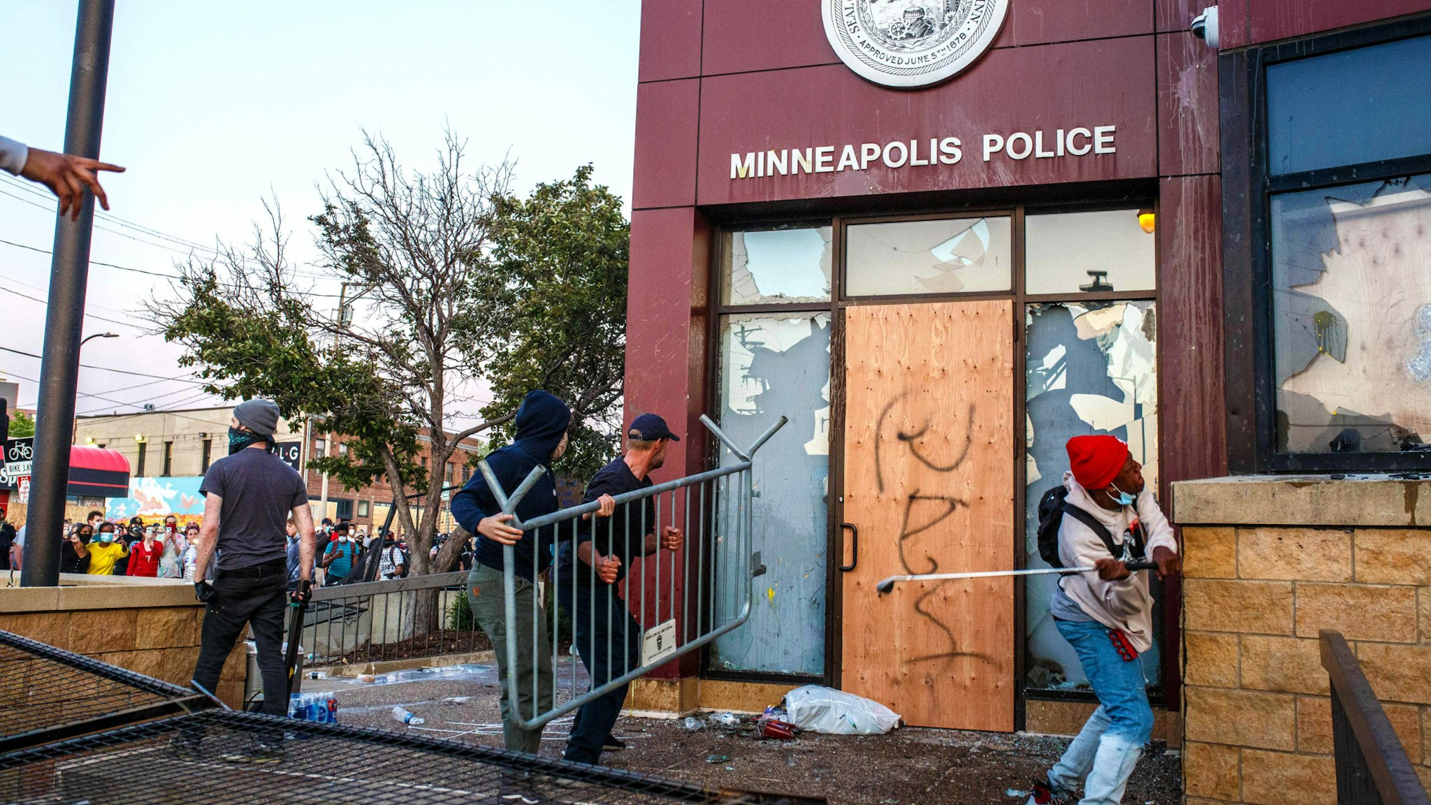 Protesters use a barricade to try and break the windows of the Third Police Precinct on May 28, 2020 in Minneapolis, Minnesota, during a protest over the death of George Floyd, an unarmed black man, died after a police officer kneeled on his neck for several minutes. - Authorities in Minneapolis and its sister city St. Paul got reinforcements from the National Guard on May 28 as they girded for fresh protests and violence over the shocking police killing of a handcuffed black man. Three days after a policeman was filmed holding his knee to George Floyd's neck for more than five minutes until he went limp, outrage continued to spread over the latest example of police mistreatment of African Americans.