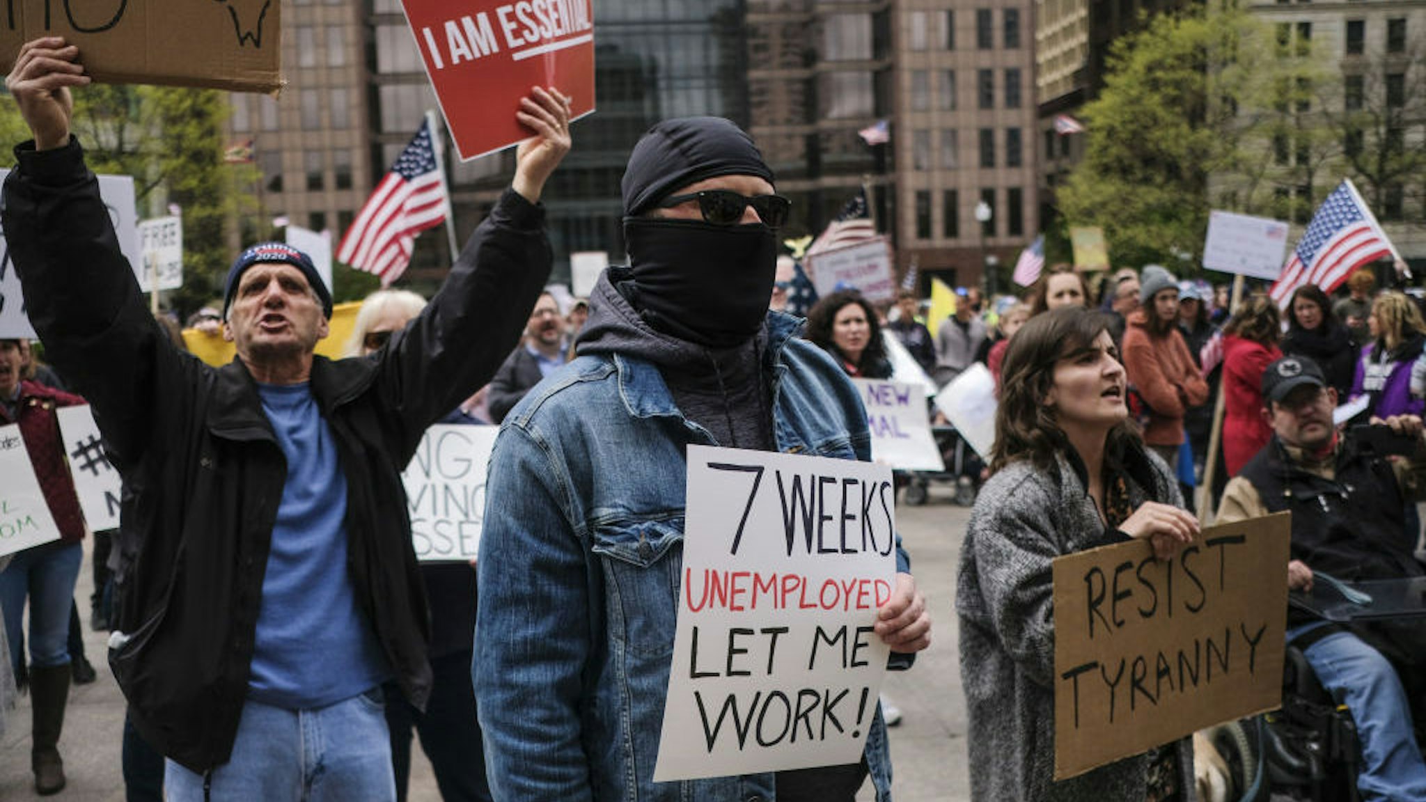 Demonstrators hold signs outside of the Ohio Statehouse in Columbus, Ohio, U.S., on Friday, May 1, 2020. Protesters gathered at the State Capitol Friday to call for the reopening of the state amid the coronavirus pandemic. Photographer: Matthew Hatcher/Bloomberg