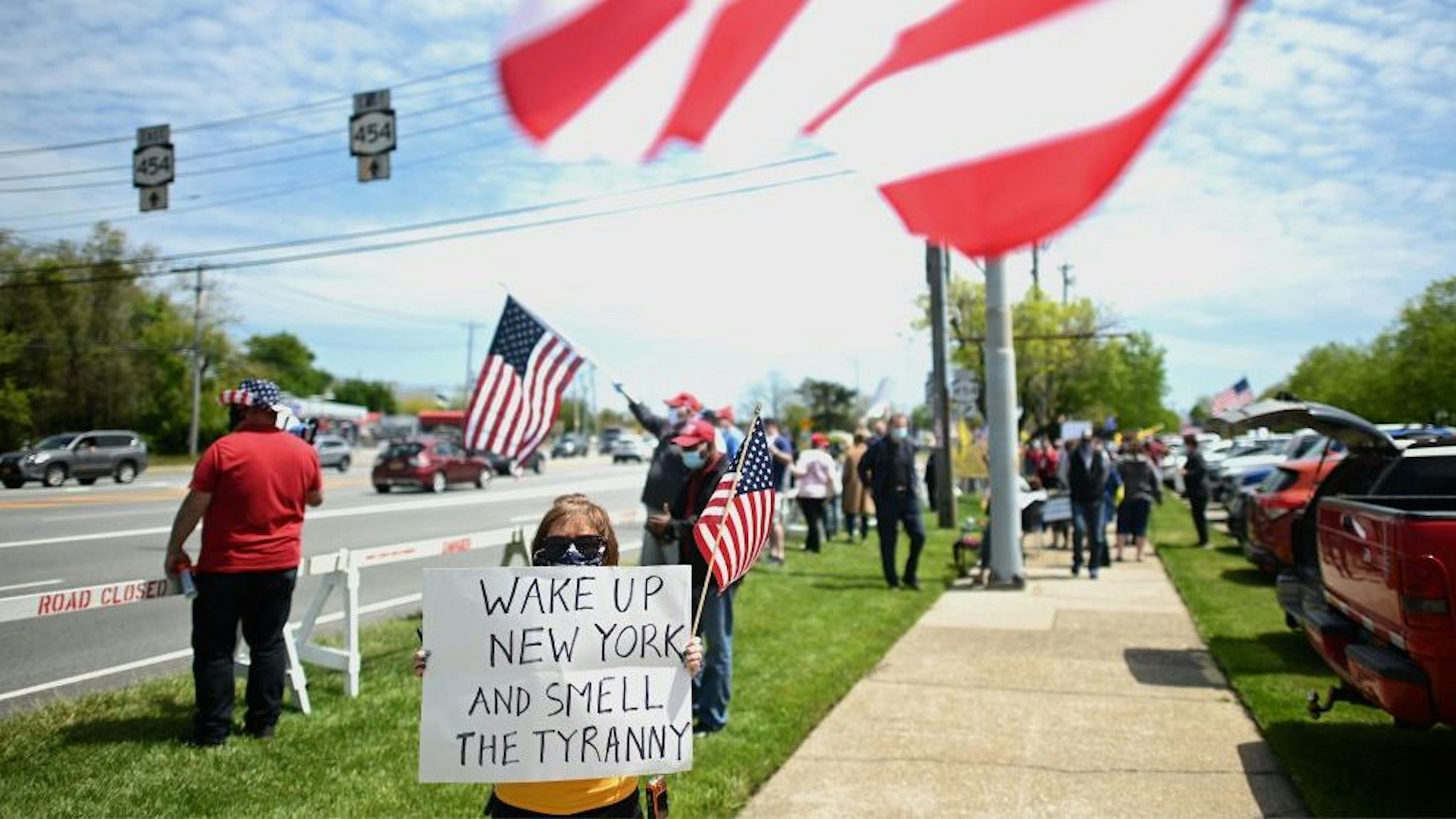 Protestors wave US flags as they attend an "Open New York" Rally on May 14, 2020 in Commack, on Long Island, New York. (Photo by Johannes EISELE / AFP)