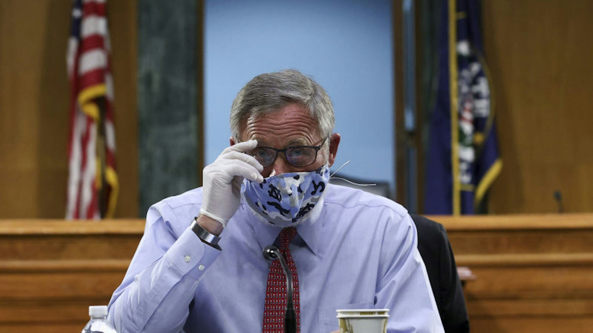 Senator Richard Burr, a Republican from North Carolina, wears a protective mask and glove while arriving to a Senate Health, Education, Labor, and Pensions Committee hearing in Washington, D.C., U.S., on Tuesday, May 12, 2020. Amid the sharpest downturn in U.S. history, President Donald Trump has been pressing to begin relaxing the lockdowns that have shuttered businesses despite warnings from some public health experts that doing so too quickly risks a further spread of the virus.