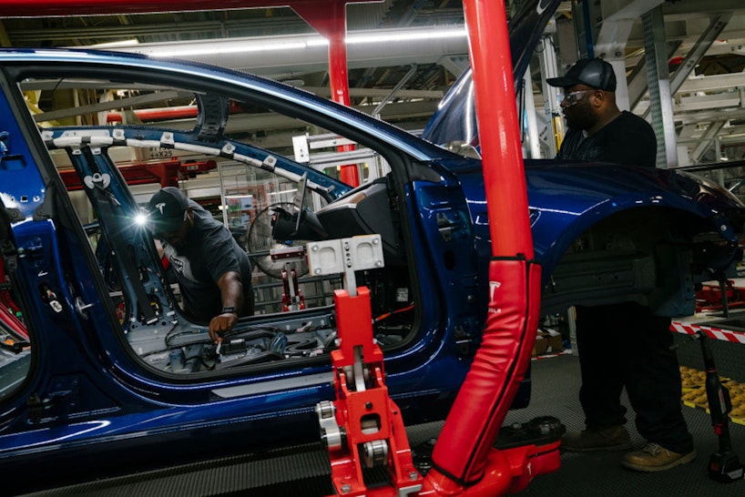 FREMONT, CA - JULY 26: Damien Boozer and Paul Jacob work on the general assembly of the Tesla Model 3 at the Tesla factory in Fremont, California, on Thursday, July 26, 2018. (