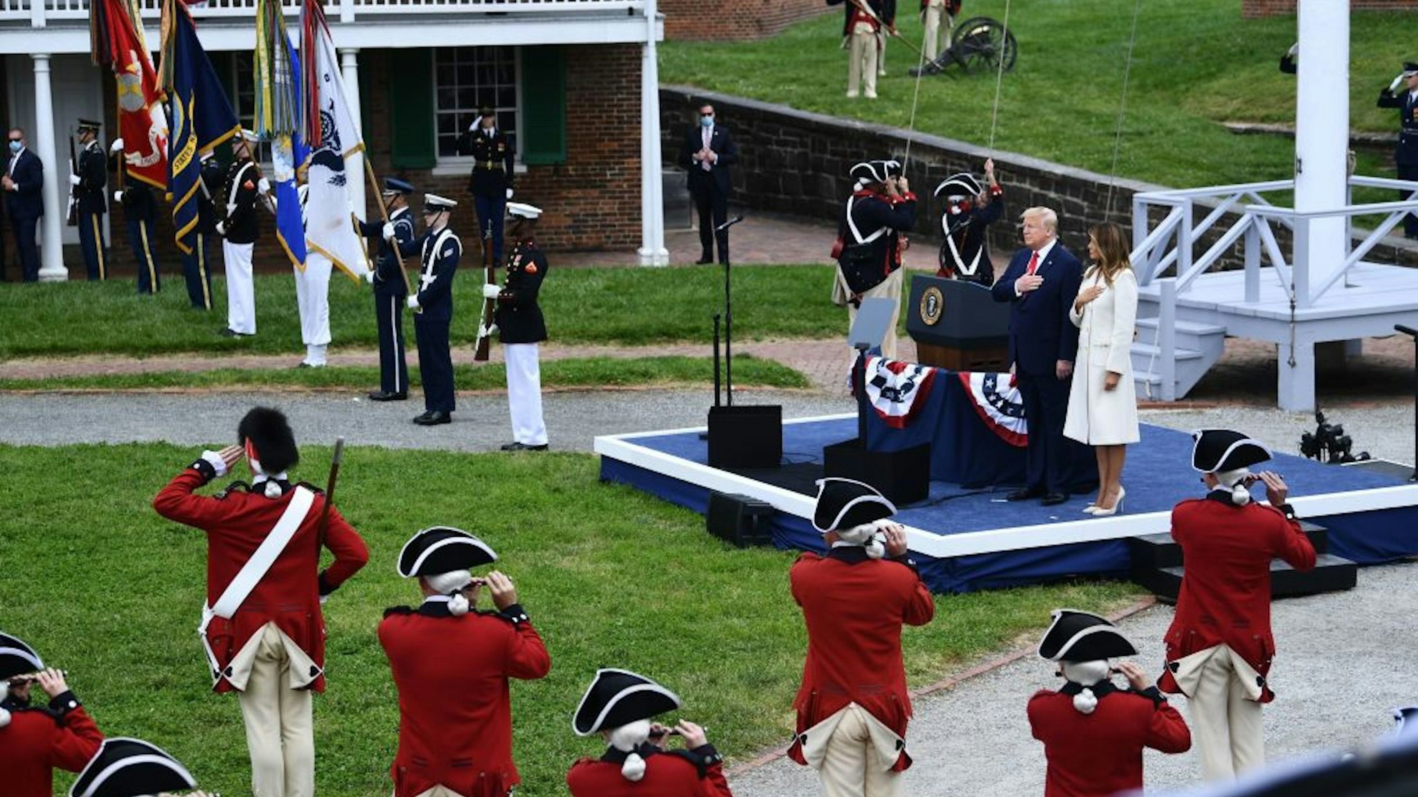 US President Donald Trump(C) and First Lady Melania Trump put their hands on their heart as they participate in a Memorial Day Ceremony at Fort McHenry National Monument and Historic Shrine on May 25, 2020 in Baltimore, Maryland. (Photo by Brendan Smialowski / AFP)