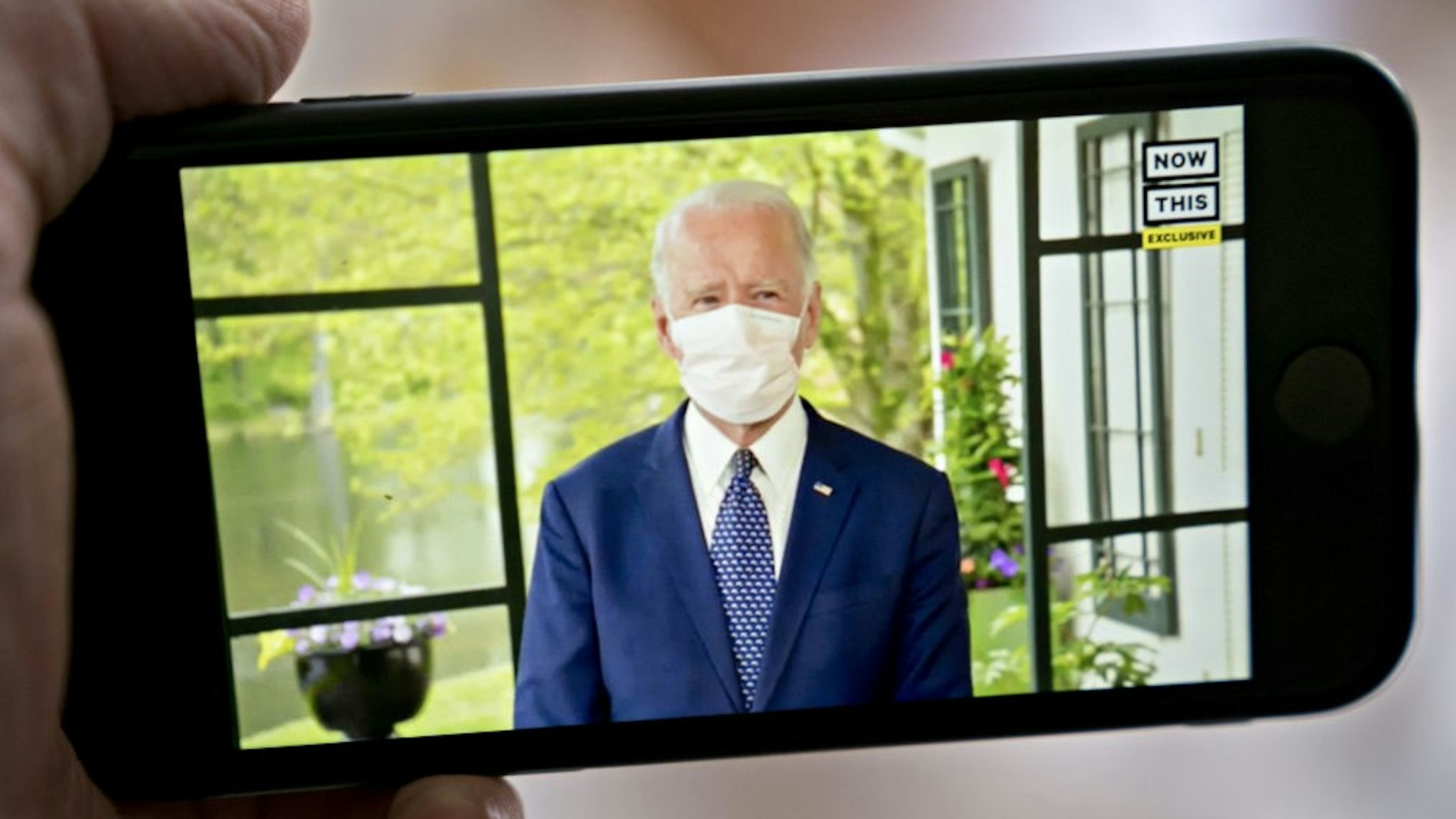 Former Vice President Joe Biden, presumptive Democratic presidential nominee, wears a protective mask during a NowThis economic address seen on a smartphone in Arlington, Virginia, U.S., on Friday, May 8, 2020. A super political action committee backing Joe Biden will launch a $10 million television ad campaign touting the presumptive Democratic nominee's leadership on the economic recovery after the 2008 financial crisis. Photographer: