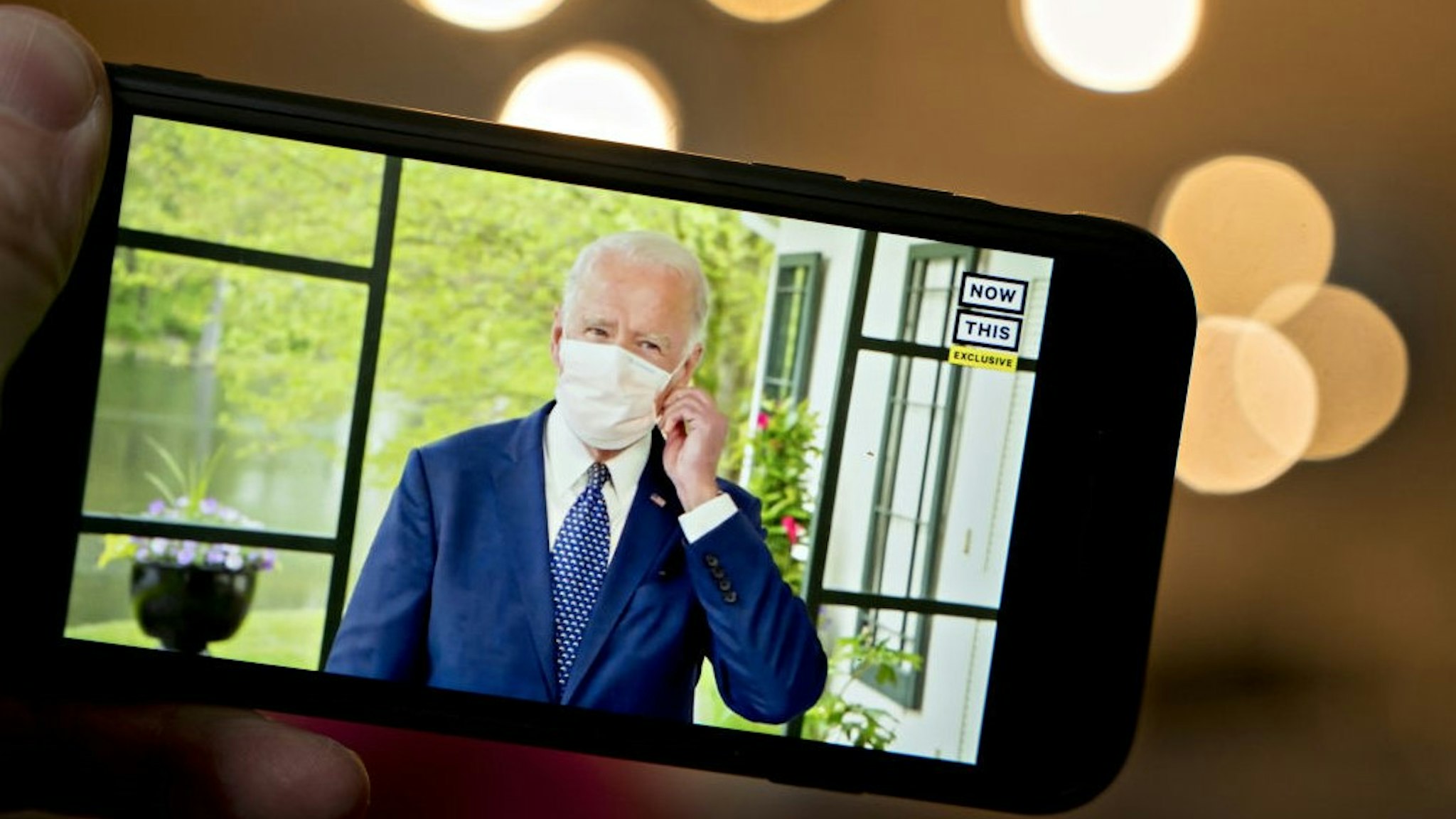 Former Vice President Joe Biden, presumptive Democratic presidential nominee, wears a protective mask during a NowThis economic address seen on a smartphone in Arlington, Virginia, U.S., on Friday, May 8, 2020. A super political action committee backing Joe Biden will launch a $10 million television ad campaign touting the presumptive Democratic nominee's leadership on the economic recovery after the 2008 financial crisis. Photographer: