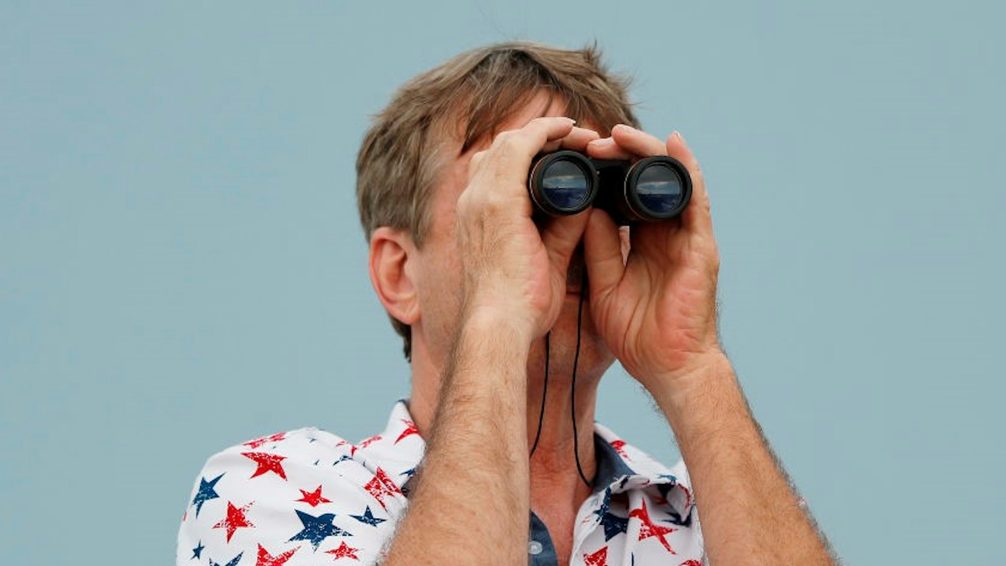 CAPE CANAVERAL, FLORIDA - MAY 27: A spectator uses binoculars to view the launch pad prior to the launch of SpaceX Falcon 9 rocket, with the manned Crew Dragon spacecraft at the Kennedy Space Center, which NASA later scrubbed due to weather conditions on May 27, 2020 in Port Canaveral, Florida. NASA will try again on Saturday for the inaugural flight that will be the first manned mission since 2011 to be launched into space from the United States. (Photo by