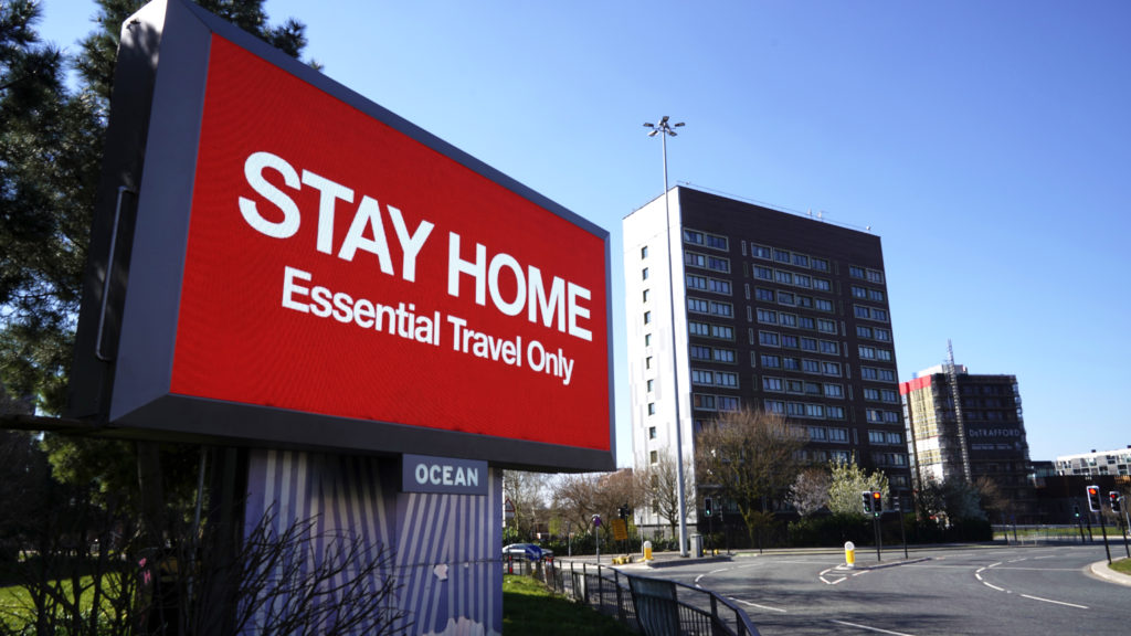 MANCHESTER, - MARCH 26: A giant television over the A57 Motorway urges people to stay home on March 26, 2020 in Manchester, England. British Prime Minister, Boris Johnson, announced strict lockdown measures urging people to stay at home and only leave the house for basic food shopping, exercise once a day and essential travel to and from work. The Coronavirus (COVID-19) pandemic has spread to at least 182 countries, claiming over 10,000 lives and infecting hundreds of thousands more.